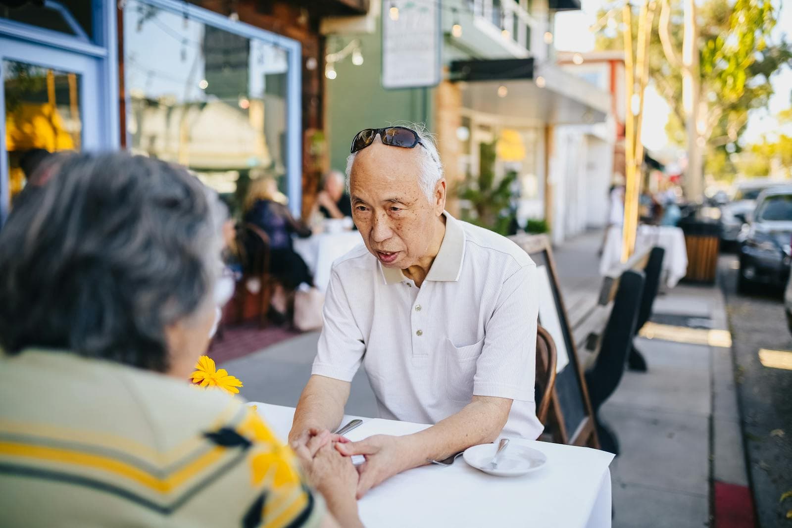 ลูกสาวจับมือพ่อสูงอายุระหว่างพูดคุยเรื่องสำคัญในครอบครัว