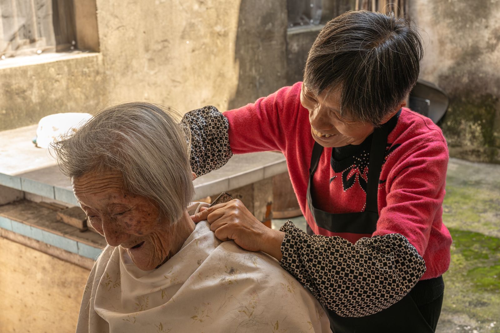 A caregiver helping an elderly woman with her daily grooming