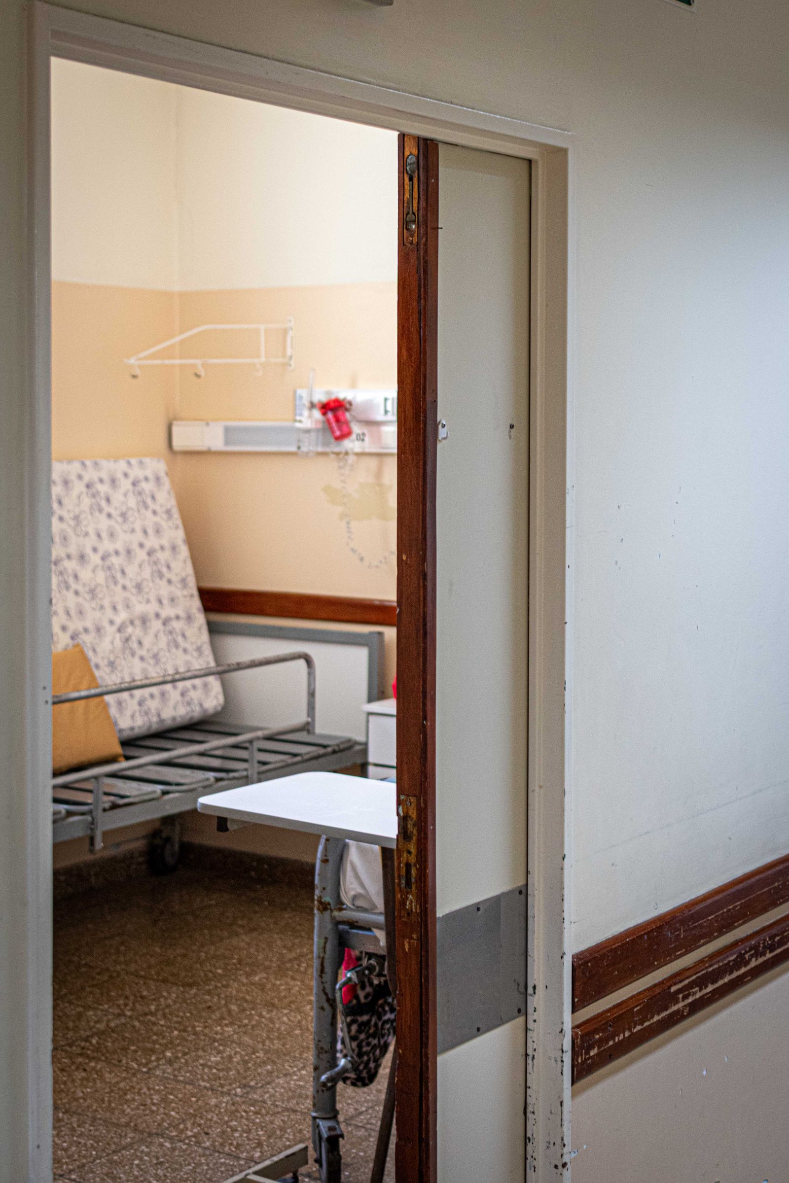 An empty care bed in a quiet room ready to receive a patient