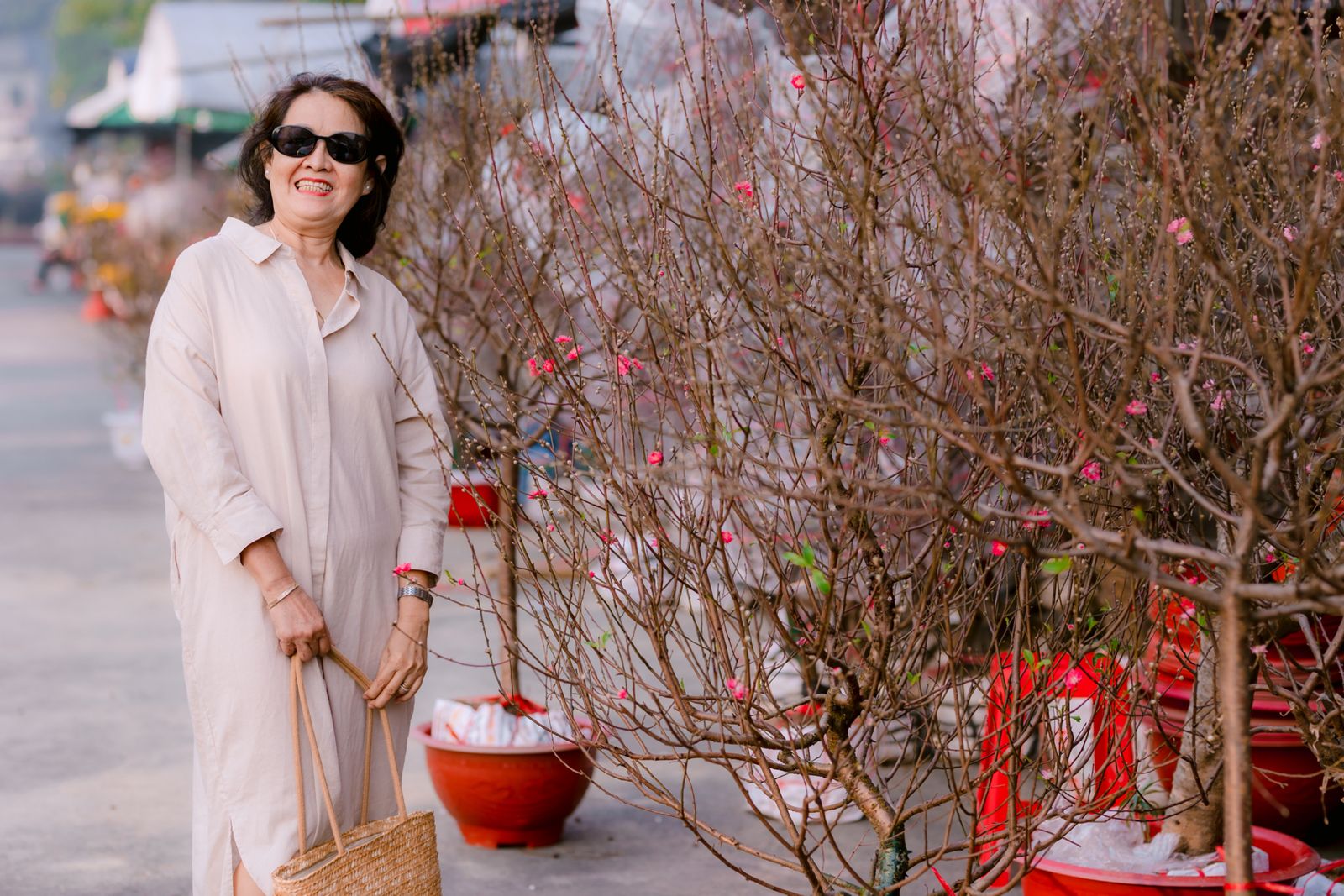 A cheerful elderly Thai woman shopping at a city flower market